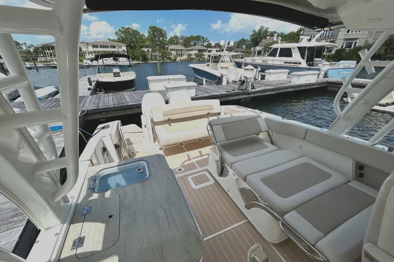 Slide: The Image of 2017 Boston Whaler 320 Vantage boat interior at marina, featuring seating and dock view. - 24