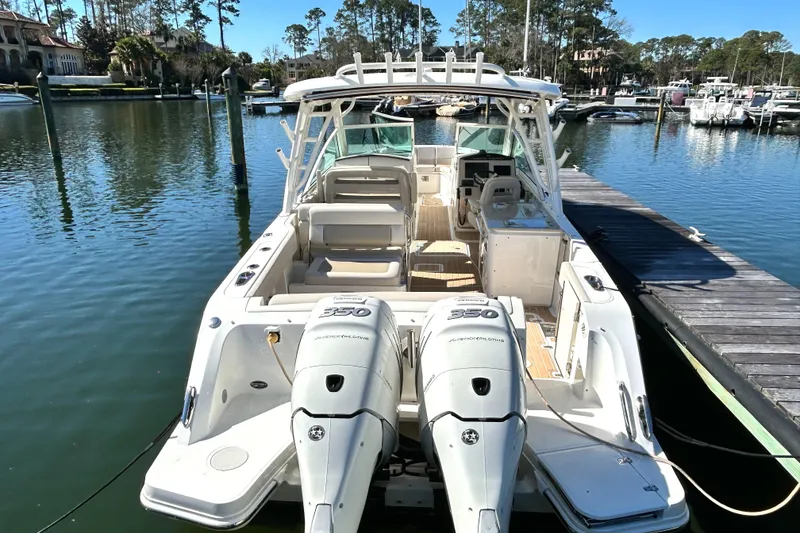 Slide: The Image of 2017 Boston Whaler 320 Vantage docked, featuring dual outboard engines, in a serene marina setting. - 3