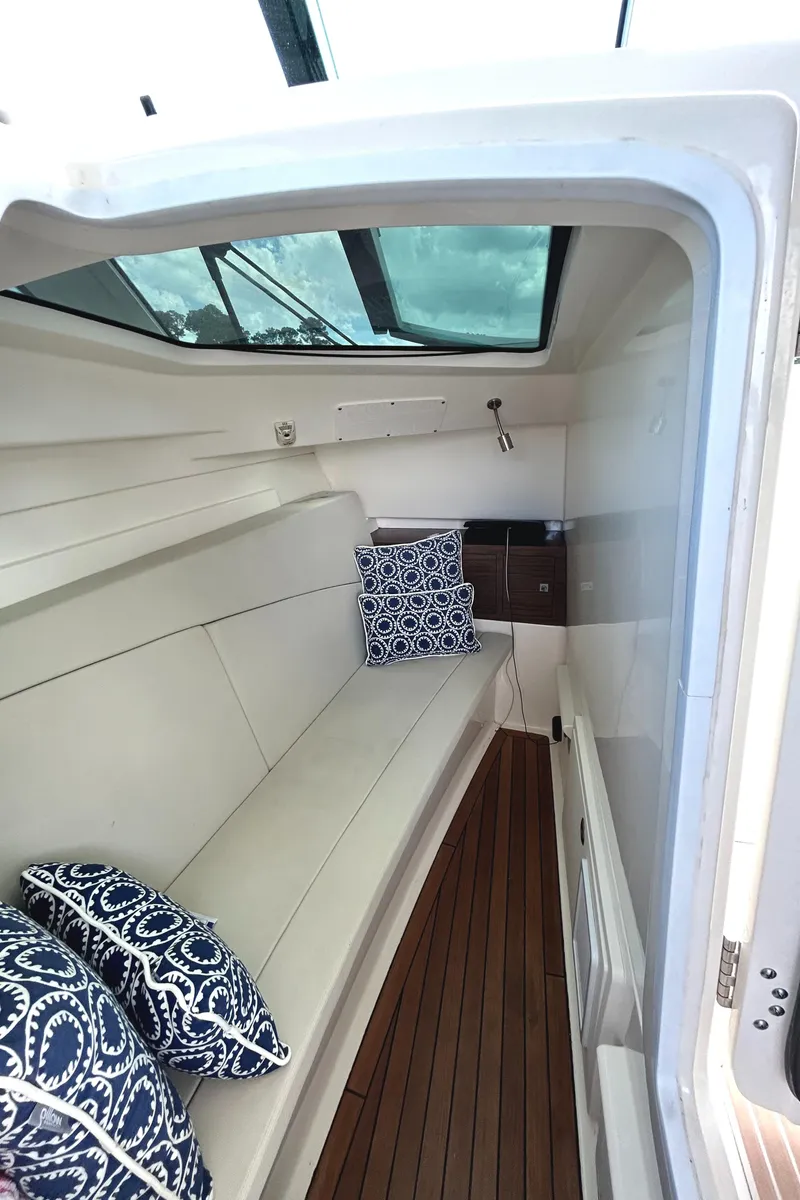Slide: The Image of 2017 Boston Whaler 320 Vantage cabin interior with cushions and wooden flooring. - 34