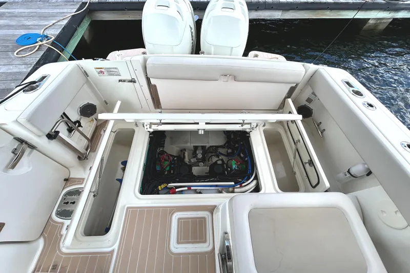 Slide: The Image of 2017 Boston Whaler 320 Vantage boat interior with open engine compartment at dock. - 37