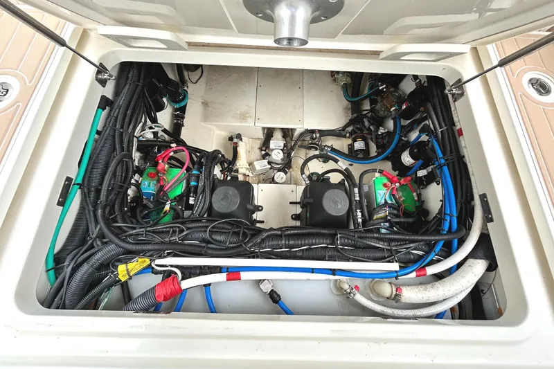 Slide: The Image of Engine compartment of a 2017 Boston Whaler 320 Vantage, showcasing wiring and components. - 38