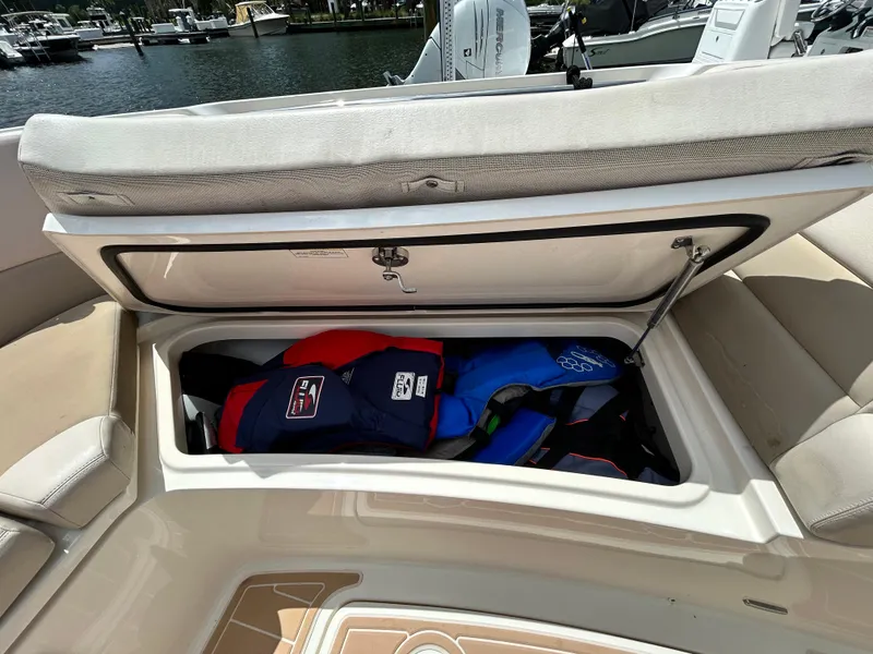 Slide: The Image of Open storage compartment on 2017 Boston Whaler 320 Vantage with life jackets inside. - 39