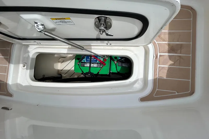 Slide: The Image of 2017 Boston Whaler 320 Vantage battery compartment with green batteries and secure latch. - 40