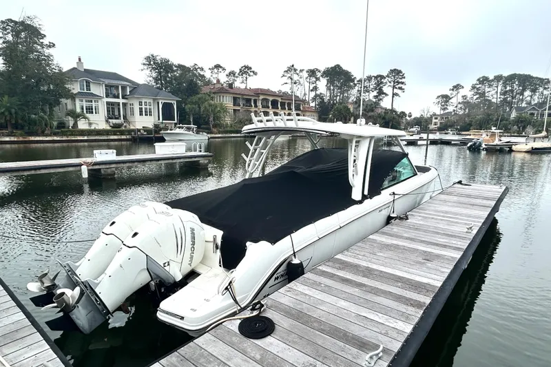Slide: The Image of 2017 Boston Whaler 320 Vantage docked at a marina, covered and ready for use. - 6