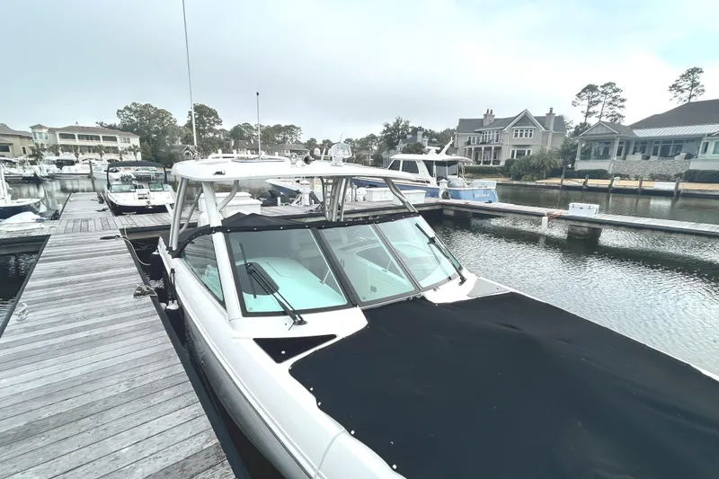 Slide: The Image of 2017 Boston Whaler 320 Vantage docked at a marina, surrounded by other boats. - 7