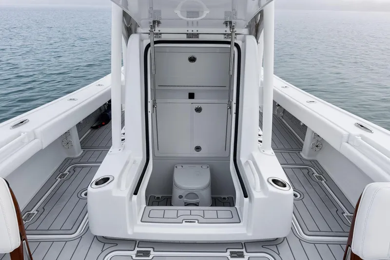 Slide: The Image of 2022 Barker Boatworks 26 Open interior with marine toilet, sleek design, and ocean backdrop. - 17