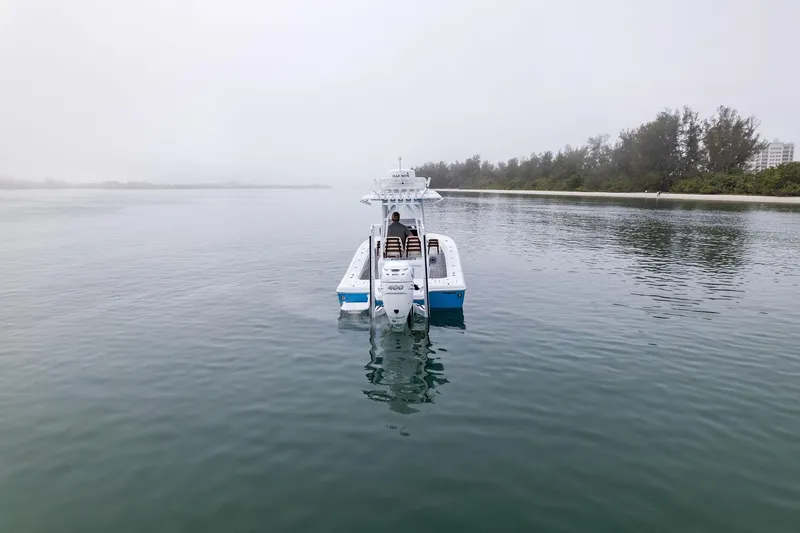 Slide: The Image of 2022 Barker Boatworks 26 Open on calm water, misty background, serene boating scene. - 2