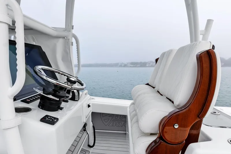 Slide: The Image of 2022 Barker Boatworks 26 Open helm with white seating and steering wheel on calm water. - 23