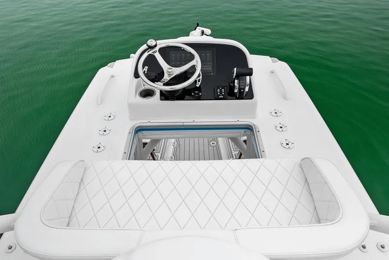 Slide: The Image of 2022 Barker Boatworks 26 Open helm with white seating and steering wheel on green water. - 27