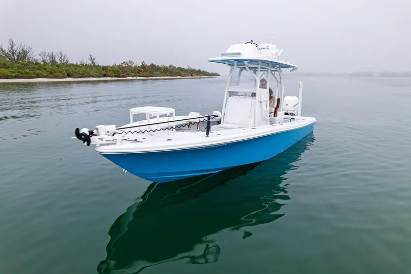 Slide: The Image of 2022 Barker Boatworks 26 Open in calm waters, showcasing sleek design and vibrant blue hull. - 5