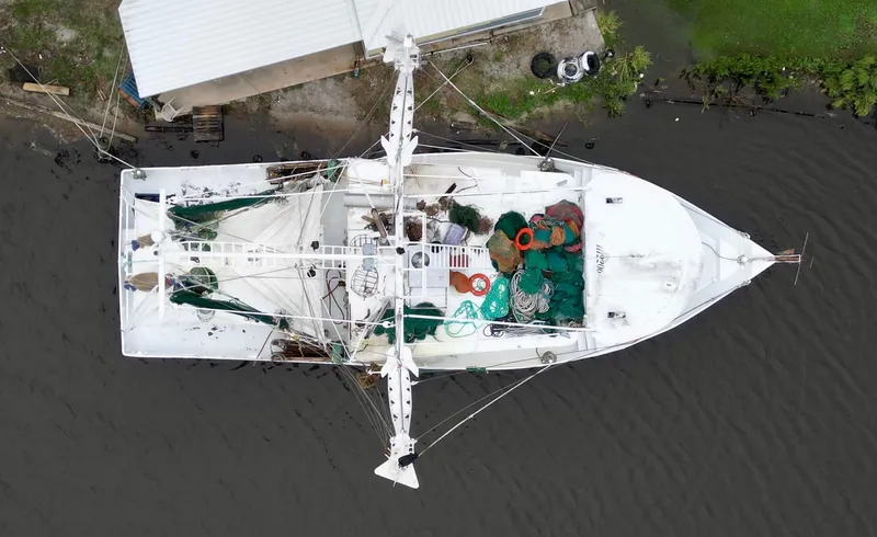 Slide: The Image of Aerial view of 2001 Blanchard 69 Shrimper/Freezer docked, showcasing fishing equipment. - 11