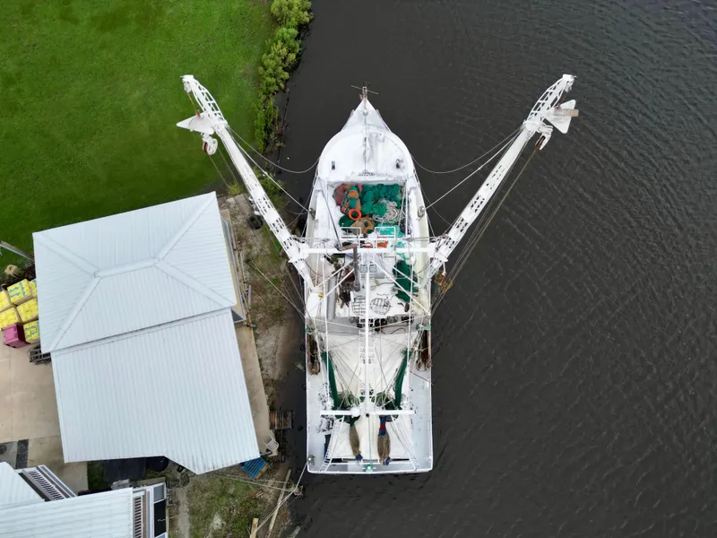 Slide: The Image of Aerial view of 2001 Blanchard 69 Shrimper/Freezer docked by a riverside building. - 12