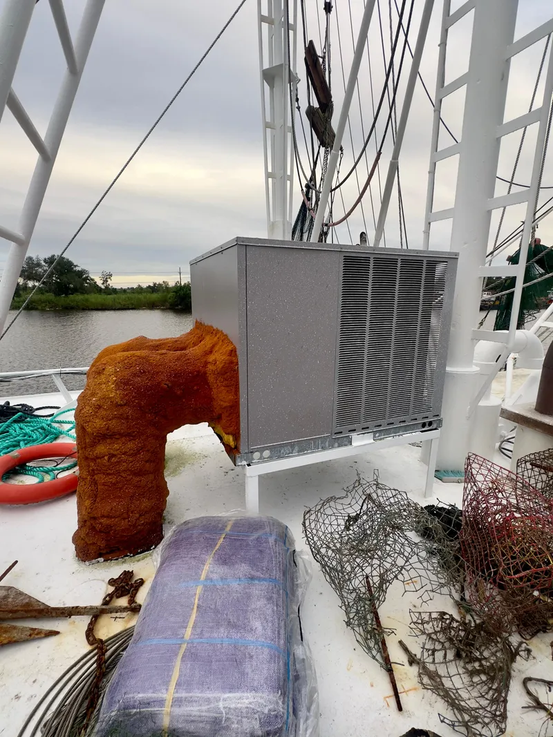 Slide: The Image of Blanchard 69 Shrimper/Freezer 2001 on deck with equipment and nets, near water. - 23