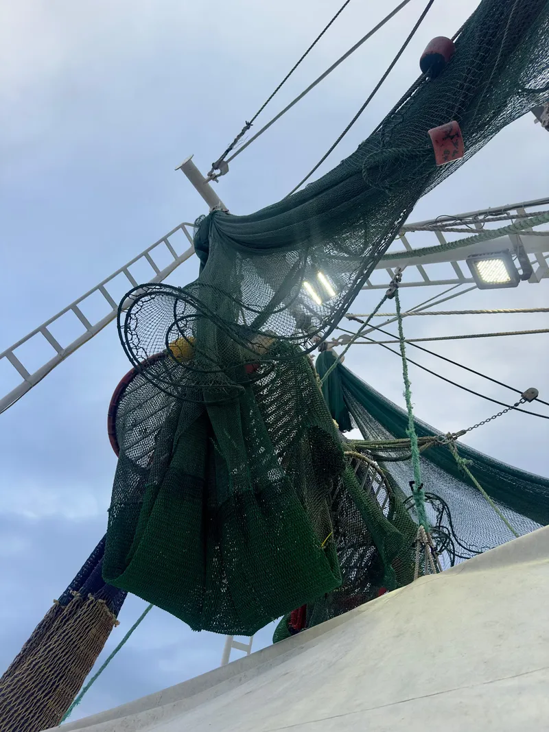 Slide: The Image of Fishing nets on Blanchard 69 Shrimper/Freezer boat, 2001 model, against cloudy sky. - 29