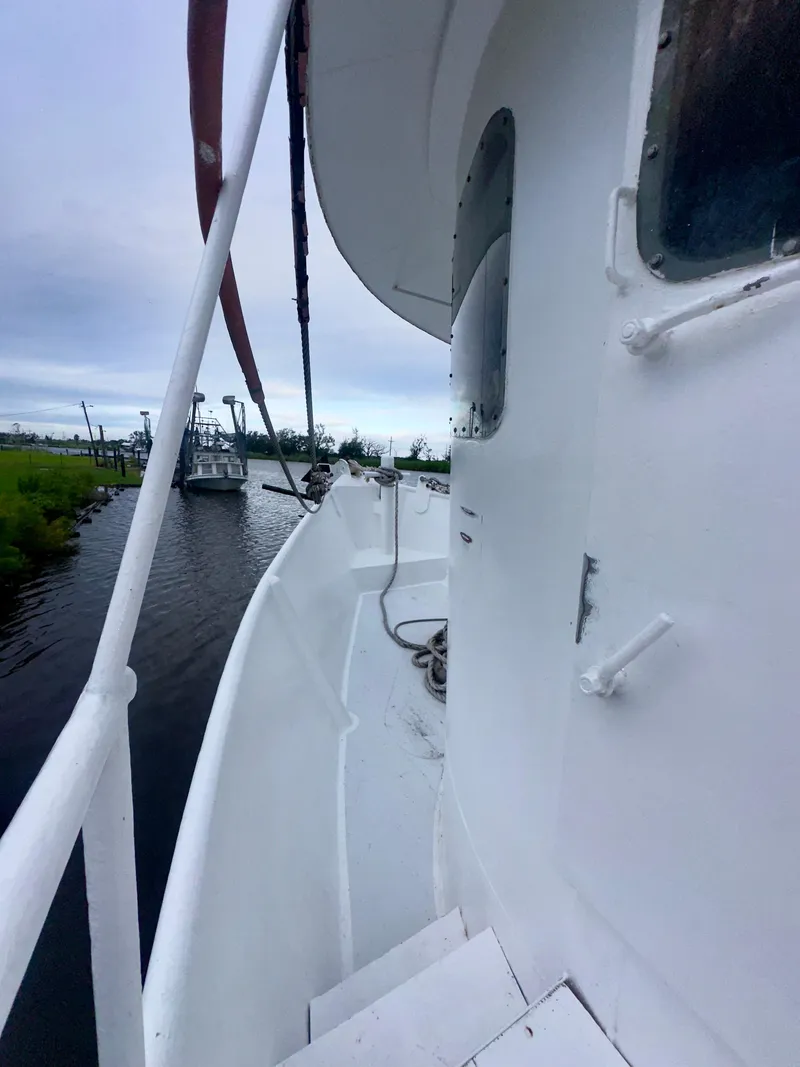 Slide: The Image of Side view of a 2001 Blanchard 69 Shrimper/Freezer boat docked by a riverbank. - 38