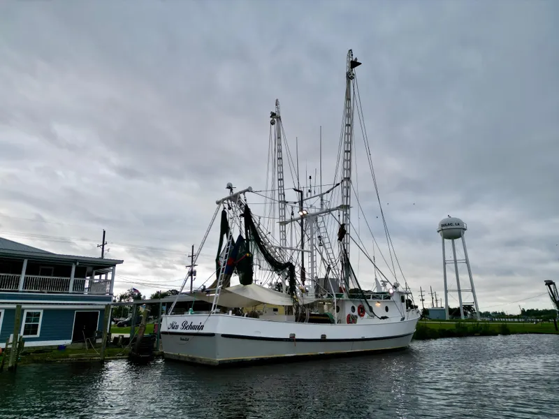 Slide: The Image of Blanchard 69 Shrimper/Freezer boat docked near water tower, overcast sky. - 8