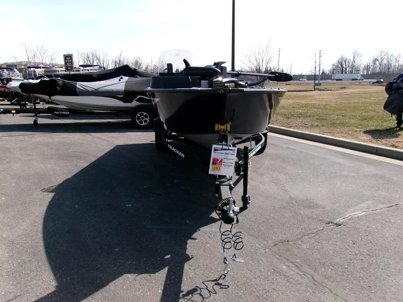 Slide: The Image of 2025 Tracker Pro Guide V-16 SC boat on trailer in parking lot. - 2