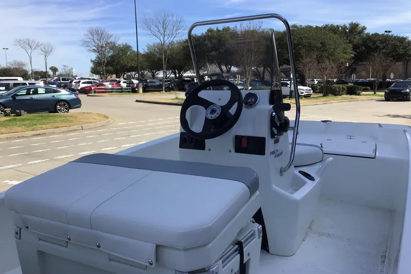 Slide: The Image of 2025 Mako Pro Skiff 15 CC boat with center console in parking lot. - 2