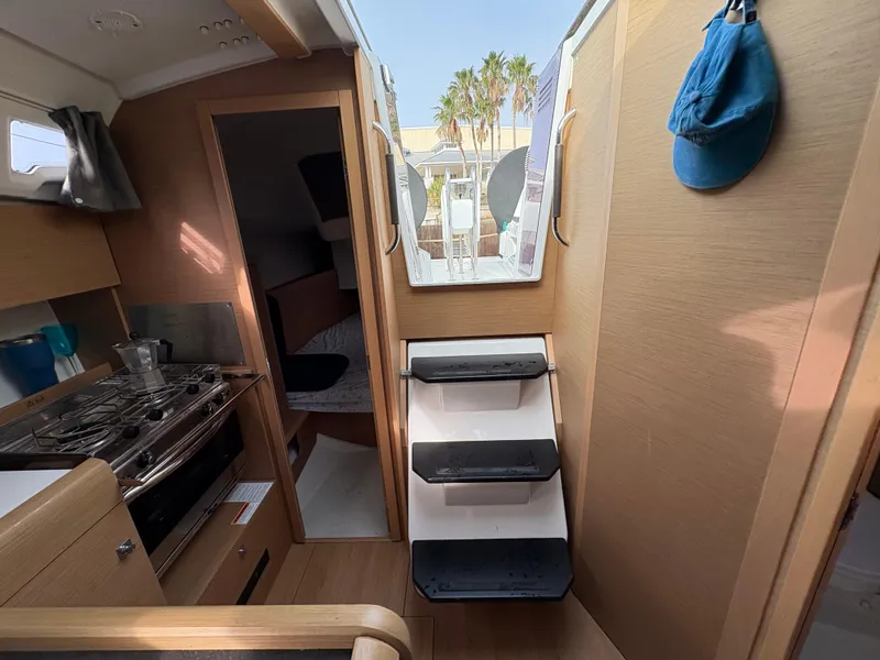 Slide: The Image of Interior of 2021 Jeanneau Sun Odyssey 349 sailboat, featuring kitchen and cabin access. - 13