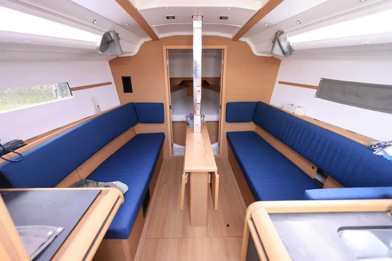 Slide: The Image of Interior of 2021 Jeanneau Sun Odyssey 349 sailboat with blue seating and wooden finishes. - 14