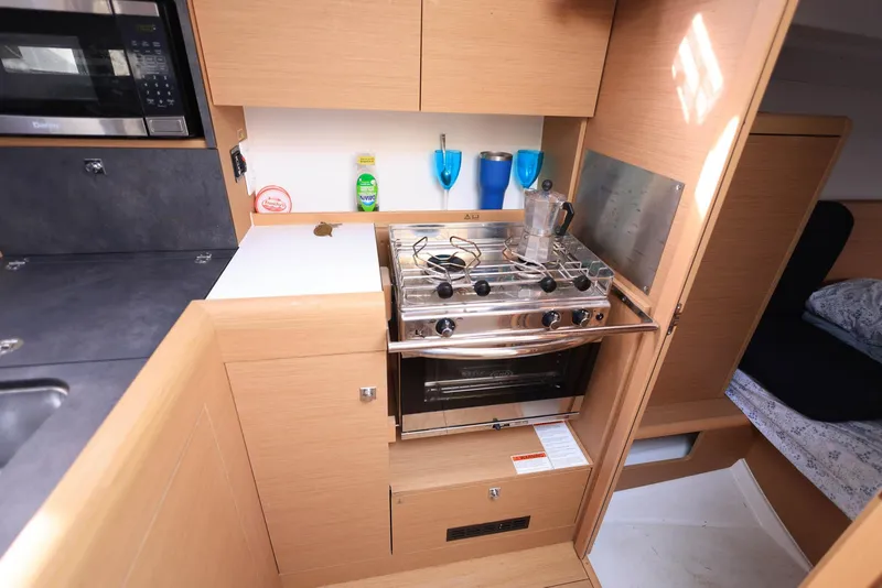 Slide: The Image of Modern kitchen in 2021 Jeanneau Sun Odyssey 349 yacht with stove and storage. - 18