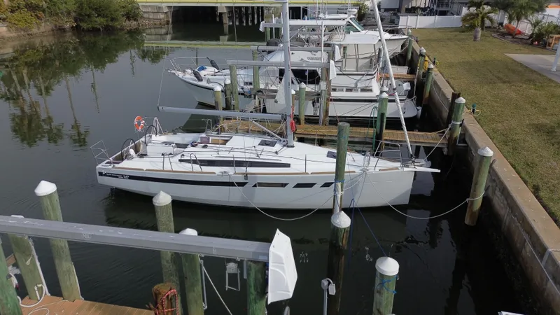 Slide: The Image of 2021 Jeanneau Sun Odyssey 349 sailboat docked in a marina. - 2