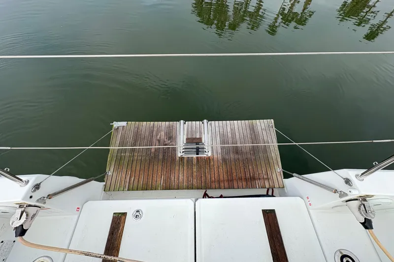 Slide: The Image of Jeanneau Sun Odyssey 349, 2021 model, rear deck view with wooden platform over calm water. - 30
