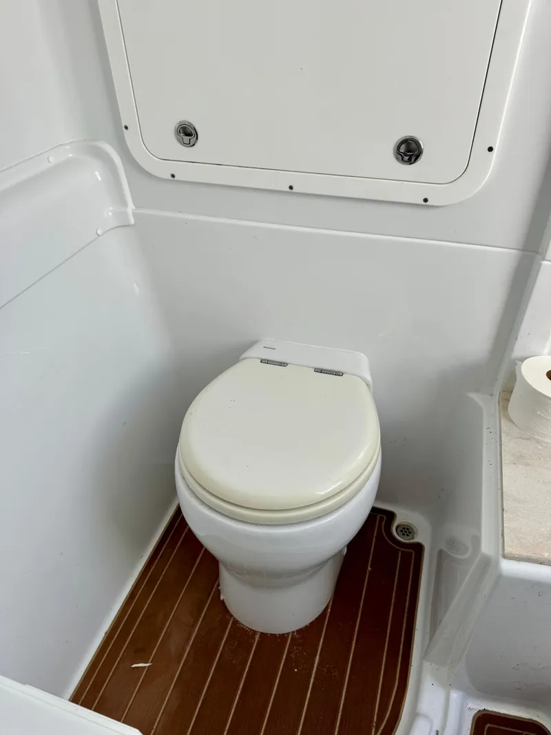 Slide: The Image of 2020 Yellowfin 42 Offshore boat bathroom with white toilet and wood flooring. - 39