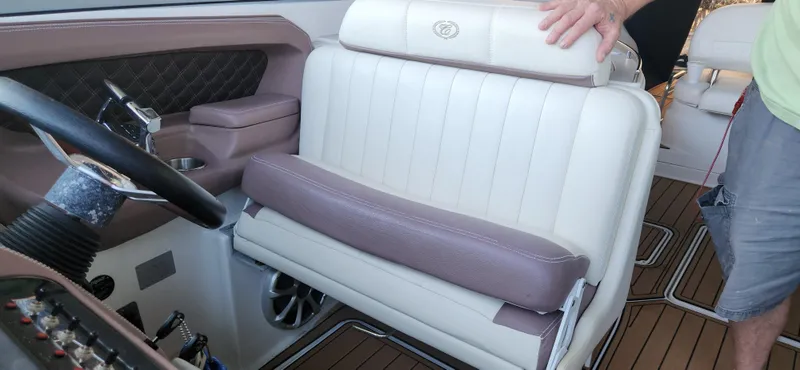 Slide: The Image of 2010 Cobalt 323 boat interior with white and purple seating, steering wheel, and wood flooring. - 23