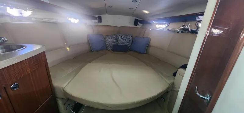 Slide: The Image of 2010 Cobalt 323 cabin interior with beige seating and blue cushions. - 28