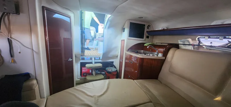 Slide: The Image of Interior of a 2010 Cobalt 323 boat featuring a cozy cabin with seating and kitchenette. - 30