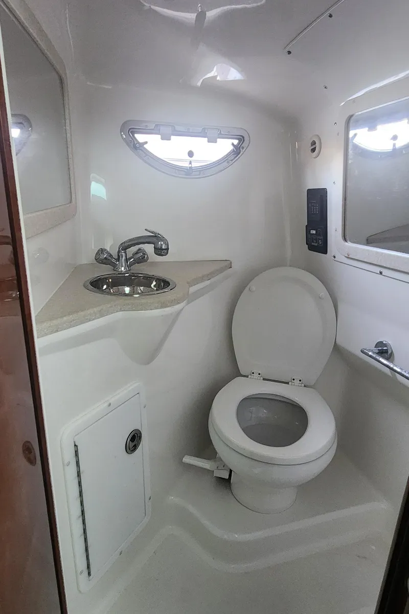 Slide: The Image of Compact marine bathroom in a 2010 Cobalt 323 boat, featuring a toilet and sink. - 31
