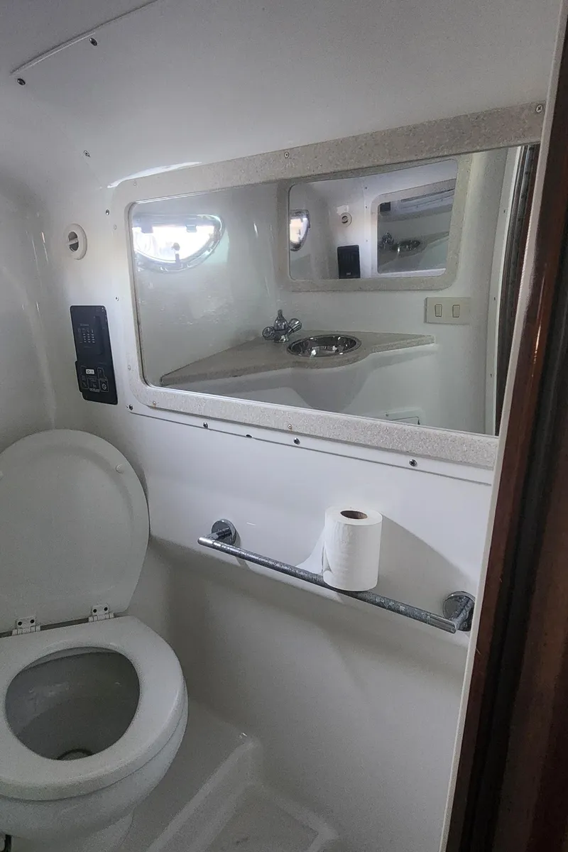 Slide: The Image of 2010 Cobalt 323 boat bathroom with toilet, mirror, and sink. - 32