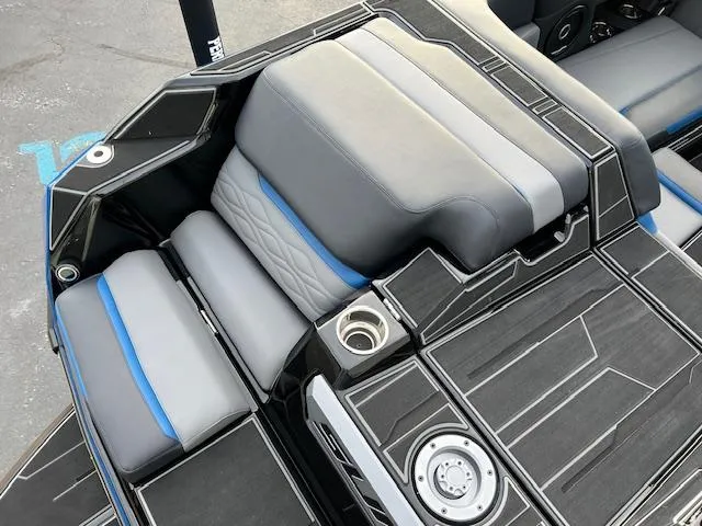 Slide: The Image of 2025 Supra SA450 boat interior with gray and blue seating, cup holder, and sleek design. - 12