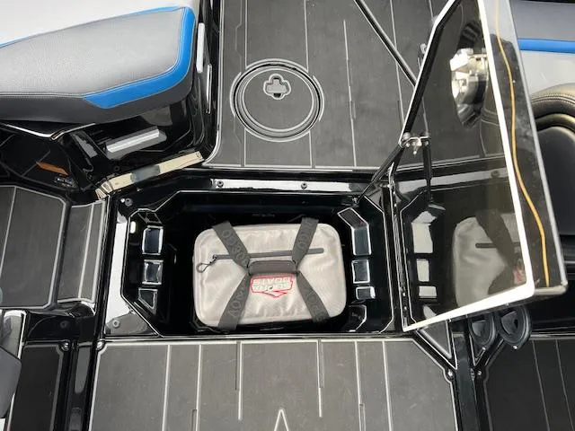 Slide: The Image of 2025 Supra SA450 boat storage compartment with secured bag and seating area. - 22