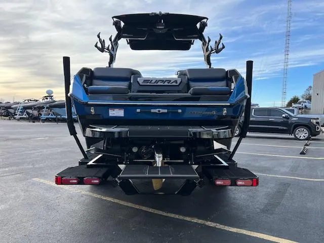 Slide: The Image of 2025 Supra SA450 boat, rear view, parked in a lot under a cloudy sky. - 5