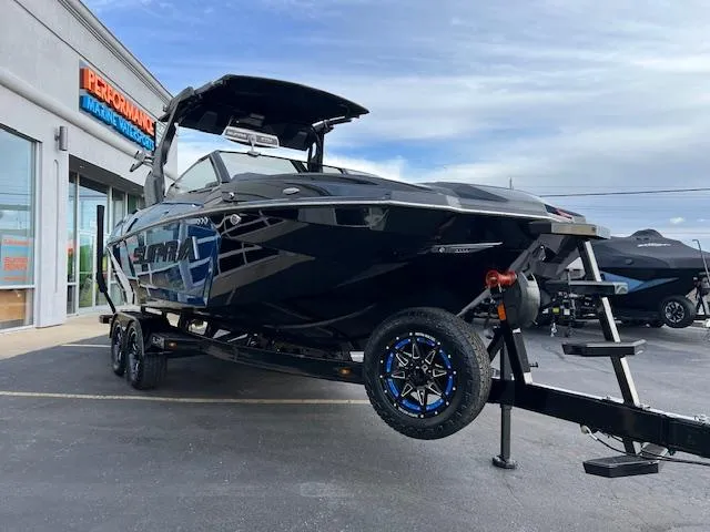 Slide: The Image of 2025 Supra SA450 boat on trailer outside dealership, showcasing sleek black design. - 9