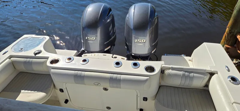 Slide: The Image of 2011 Sailfish 2360 CC boat with twin 150 horsepower engines, docked on calm water. - 13