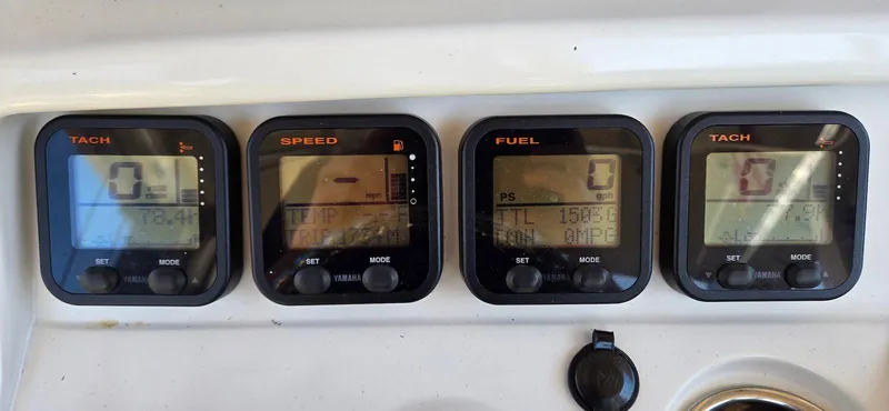 Slide: The Image of Digital gauges on a 2011 Sailfish 2360 CC boat dashboard displaying tachometer, speed, and fuel levels. - 14