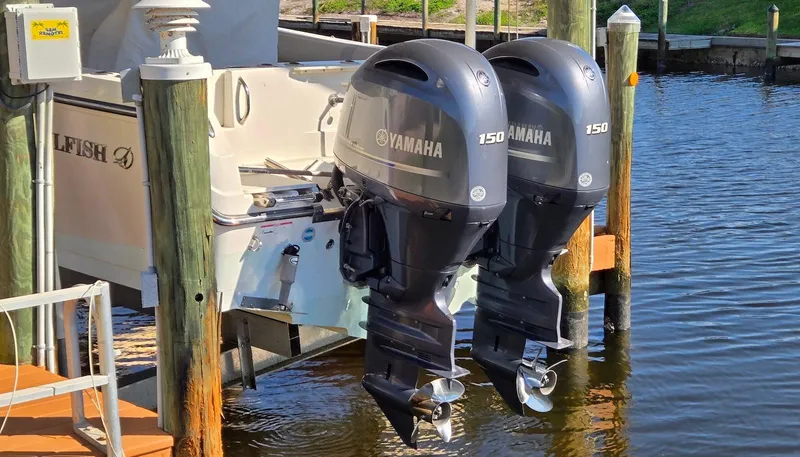 Slide: The Image of Twin Yamaha 150 engines on a 2011 Sailfish 2360 CC boat docked by wooden posts. - 15