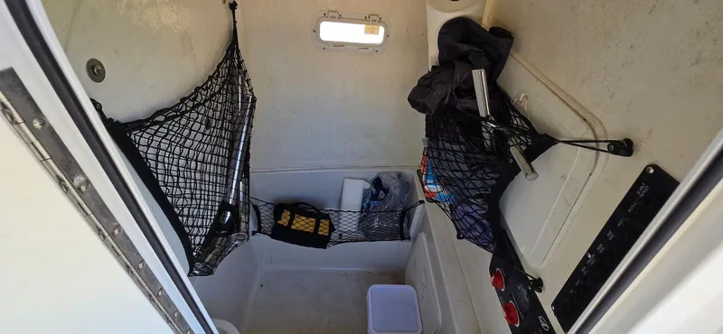 Slide: The Image of 2011 Sailfish 2360 CC cabin interior with storage nets and small window. - 18