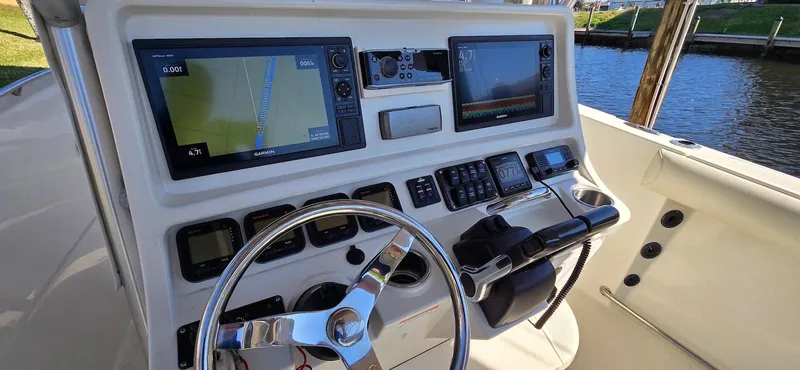 Slide: The Image of 2011 Sailfish 2360 CC boat dashboard with navigation screens and steering wheel. - 5