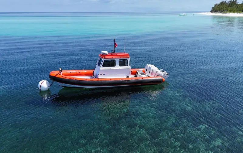 The Image of 2003 Zodiac Hurricane boat on clear blue water near a tropical shoreline. - 0
