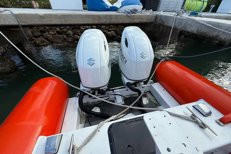 Slide: The Image of 2003 Zodiac Milpro Hurricane boat with dual Suzuki outboard motors docked by the pier. - 14