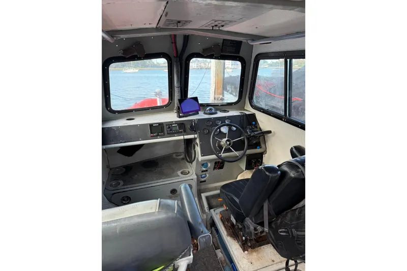 Slide: The Image of Interior of a 2003 Zodiac Milpro Hurricane boat, featuring steering wheel and navigation equipment. - 9