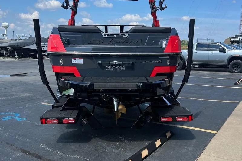 Slide: The Image of 2025 Supra SL450 boat rear view in parking lot, showcasing design and features. - 13