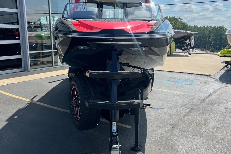 Slide: The Image of 2025 Supra SL450 boat on trailer, parked outdoors, showcasing sleek design and vibrant colors. - 14