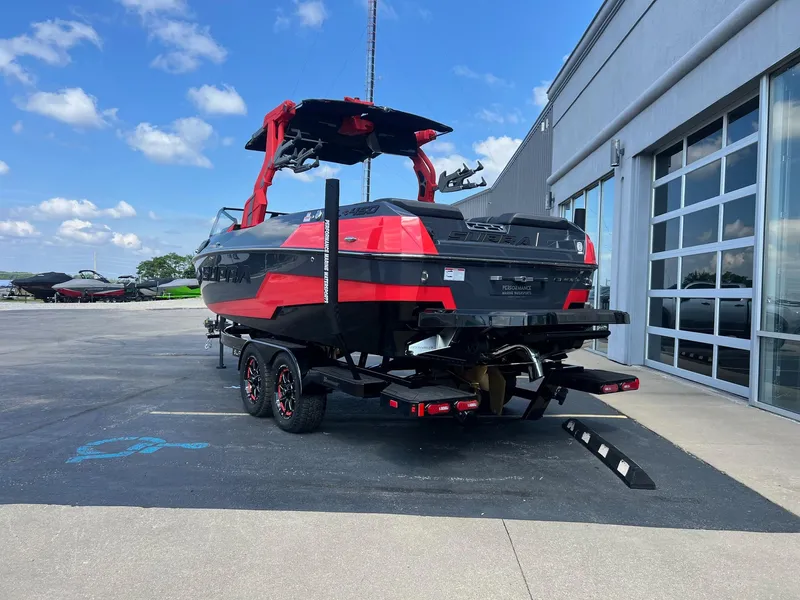 Slide: The Image of 2025 Supra SL450 boat on trailer, red and black design, parked outside dealership. - 3