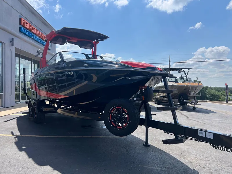 Slide: The Image of 2025 Supra SL450 boat on trailer at dealership under blue sky. - 6