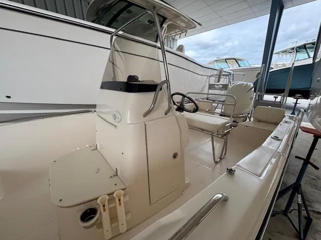 Slide: The Image of 2024 Grady-White Fisherman 180 boat interior, featuring steering console and seating in a showroom. - 13